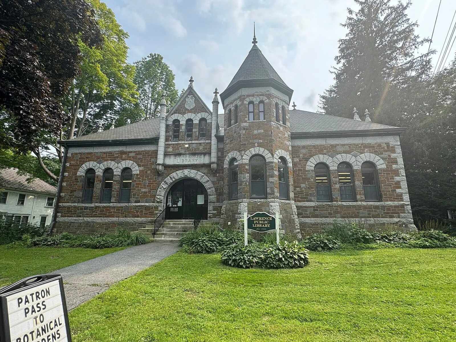 Photo of the Lawrence Public Library in Fairfield, Maine. It is a historic brick building that looks kinds of like a castle.